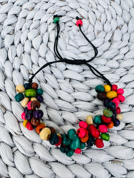 A vibrant delicate handmade wood bracelet with bright wood bead flowers.