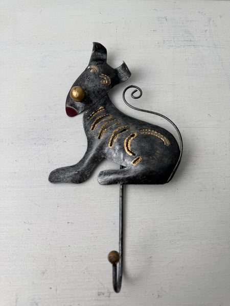 Handmade metal dog hook in silver and gold finish on white background.