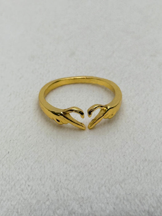 gold tone open ring with hands forming a heart shape on white background