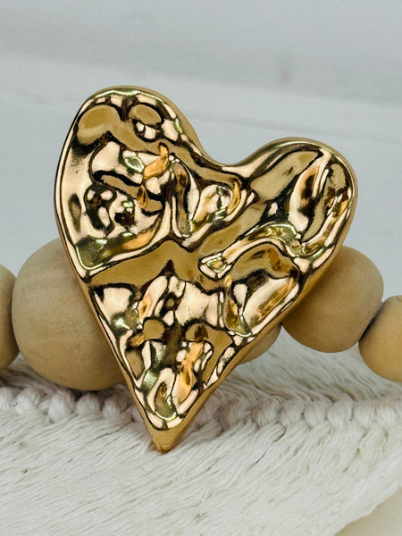 close-up of gold heart-shaped decorative brooch