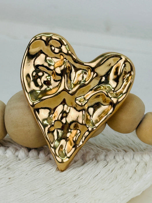 close-up of gold heart-shaped decorative brooch