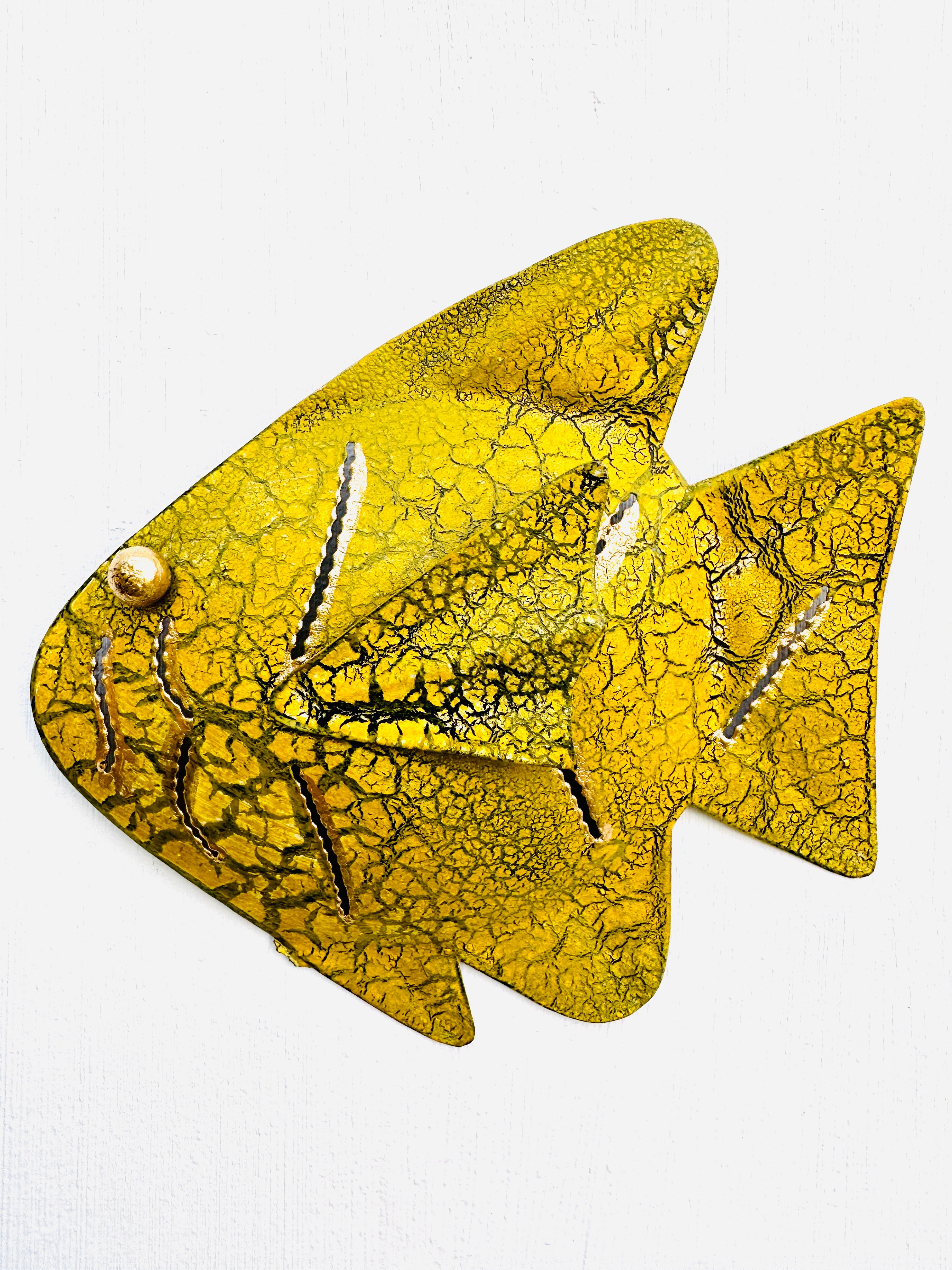 front view of single yellow metal fish on white background