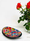 display view of mosaic oval bowl next to a vase of flowers