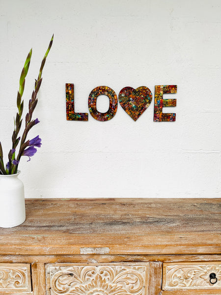 display view of LOVE attached on wall with vase of flowers