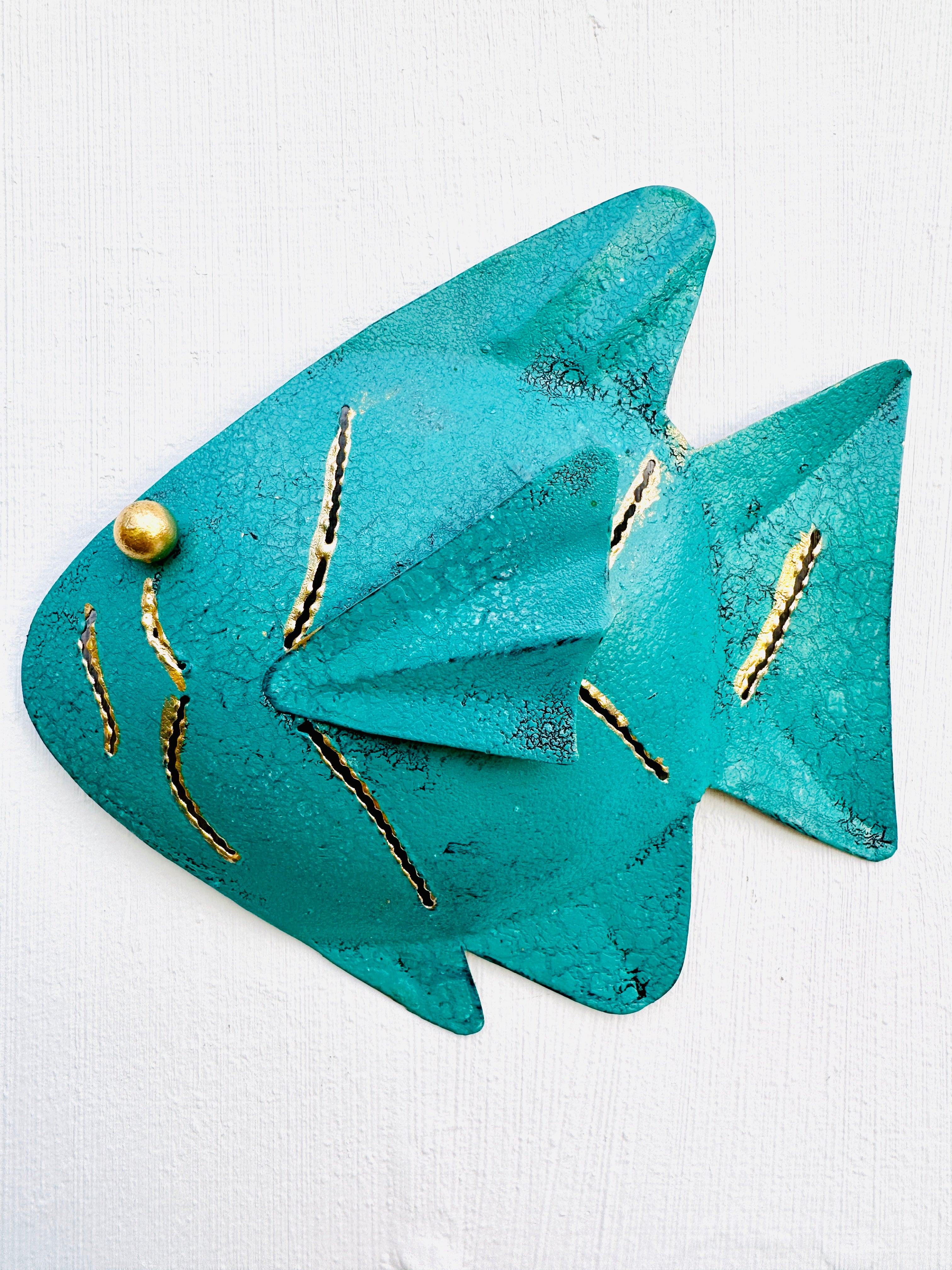 front view of single metal fish in turquoise