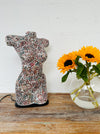 display view of mosaic bust lamp in burgundy colours stood on a wooden surface next to a vase of sunflowers