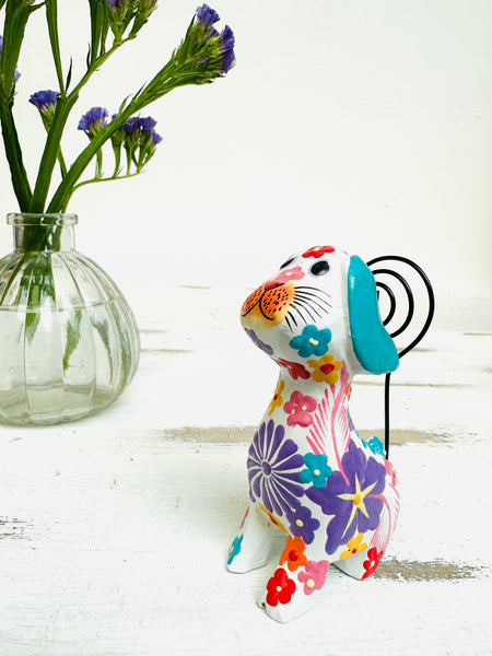 display view of flower dog in white next to a vase of flowers