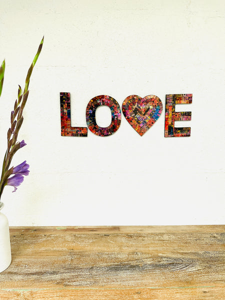 display view of mosaic love wall hanging with vase of flowers in view