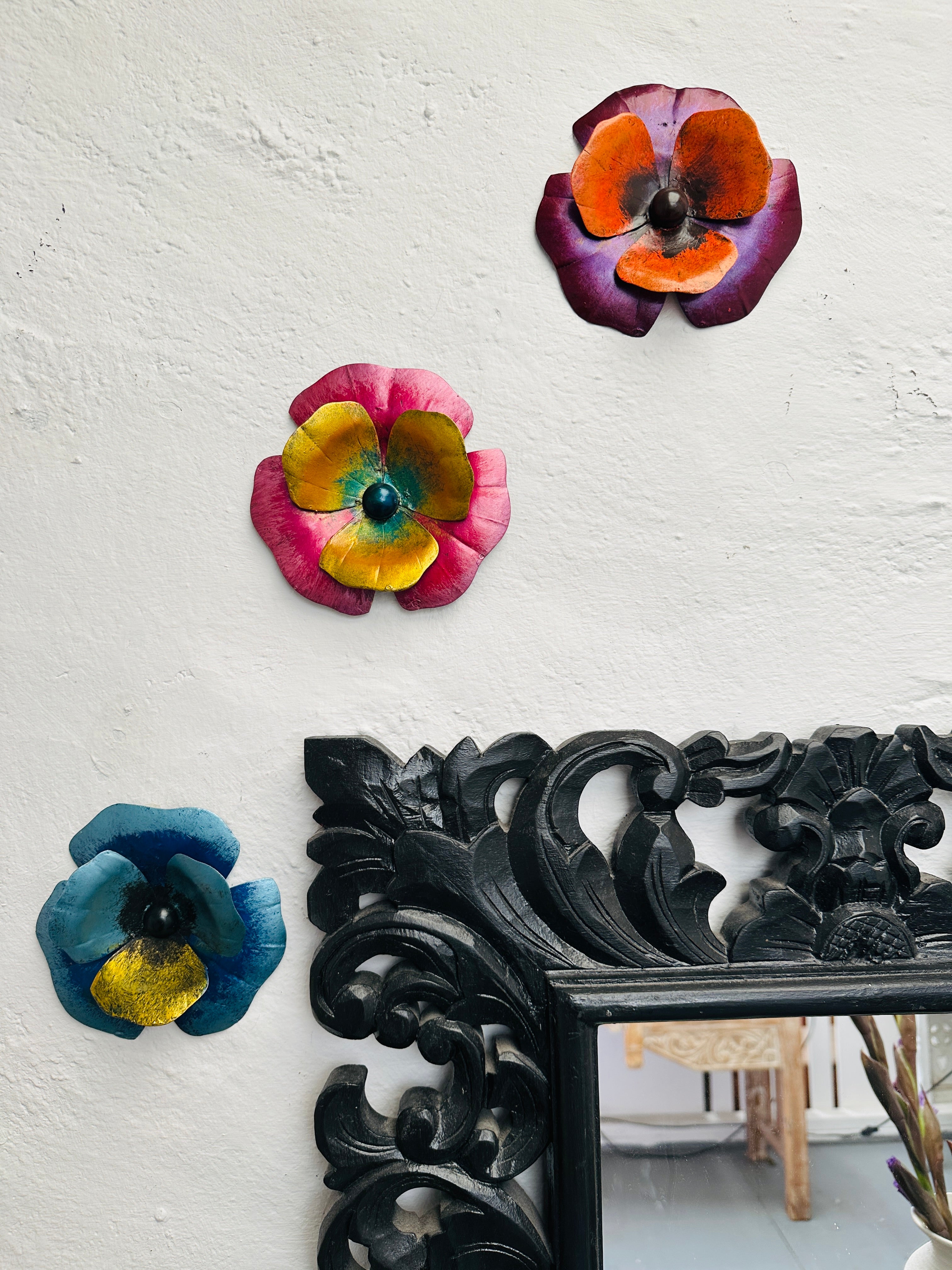 display view of assorted pansy metal flowers attached to the wall