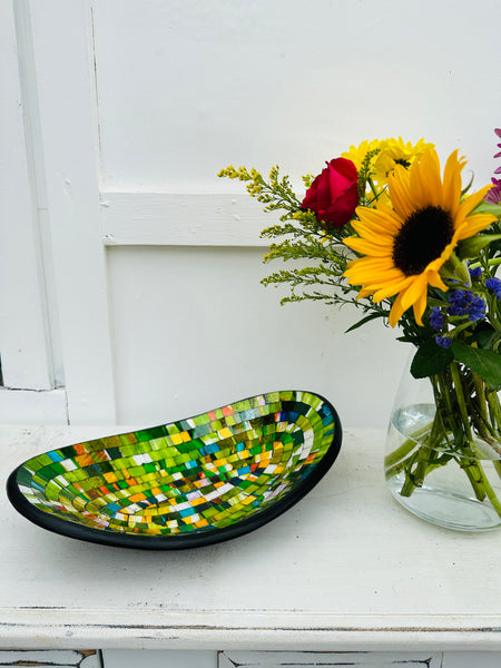 display view of mosaic oval bowl next to a flower vase.