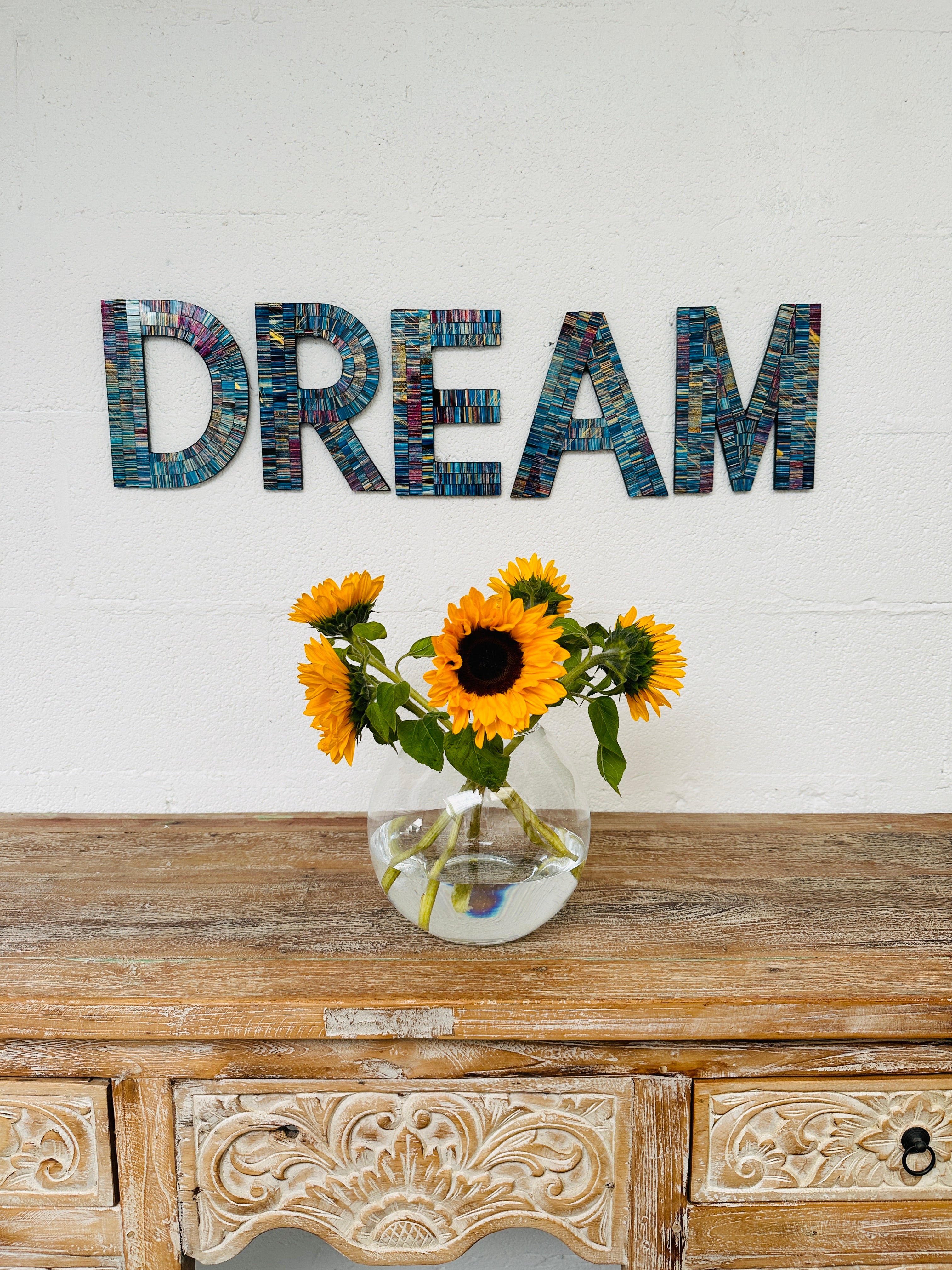 display view of mosaic DREAM above a vase of flowers on a wooden dresser.