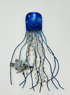 A blue metal jellyfish wall art with coiled tentacles and a small fish attached.