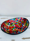 Angled top view of large handmade mosaic oval bowl in Fragaria tones with red, gold and blue glass pattern.