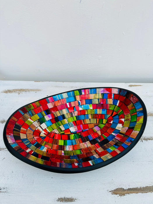 Angled top view of large handmade mosaic oval bowl in Fragaria tones with red, gold and blue glass pattern.
