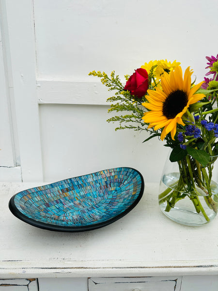 display view of mosaic oval bowl next to a vase of flowers