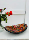 display view of mosaic oval bowl next to a vase of roses