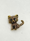 Cat-shaped brooch with rhinestones on a white background