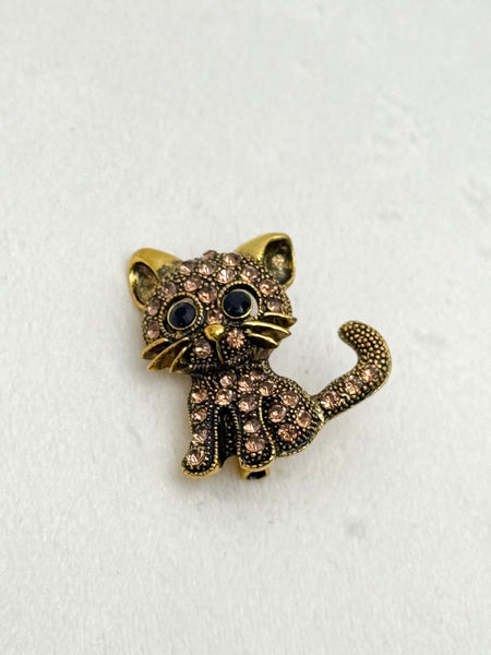 Cat-shaped brooch with rhinestones on a white background
