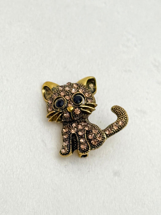 Cat-shaped brooch with rhinestones on a white background