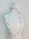 A long double-chain mixed metal heart charm necklace with a silver and gold hearts displayed on a mannequin