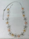 Necklace with floral designs in silver, gold, and rose gold on a white background