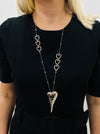 Long heart link pendant necklace with multiple metal rose-gold hearts on a silver chain displayed on a model