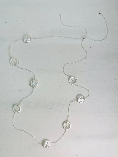 front of long silver chain station necklace with acrylic faux-shell circles 