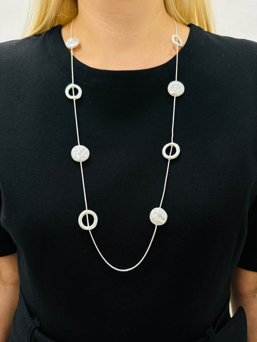 Long silver chain station necklace with acrylic faux-shell circles displayed on a model