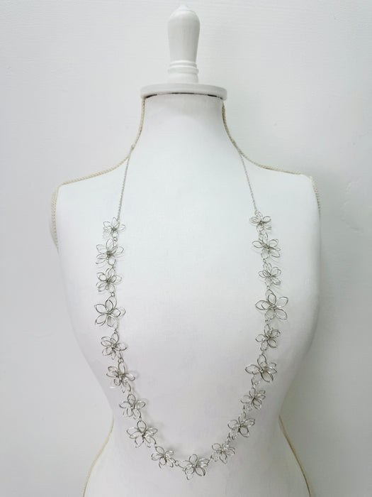 Silver floral necklace on a mannequin 