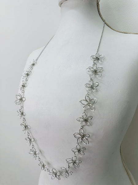 side angle of silver floral necklace on a mannequin 