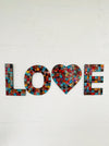 front view of mosaic love on white wall