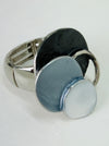 Silver-tone elastic ring with three layered enamel discs in dark and light grey.