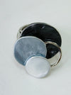 Silver-tone elastic ring with three layered enamel discs in dark and light grey.