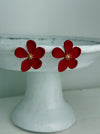 close-up of matte red flower-shaped earrings on a white background