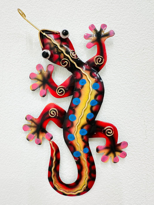Front view of red metal gecko showing colourful painted details and curled tail