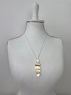 Necklace with three pendant stones on a mannequin bust against a plain background