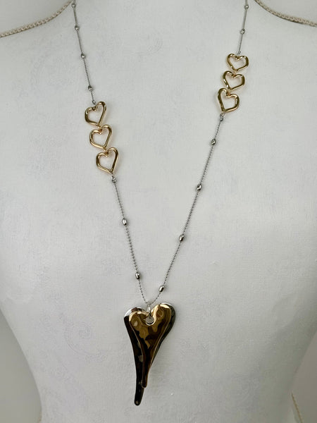 Necklace with a heart-shaped pendant on a mannequin bust.