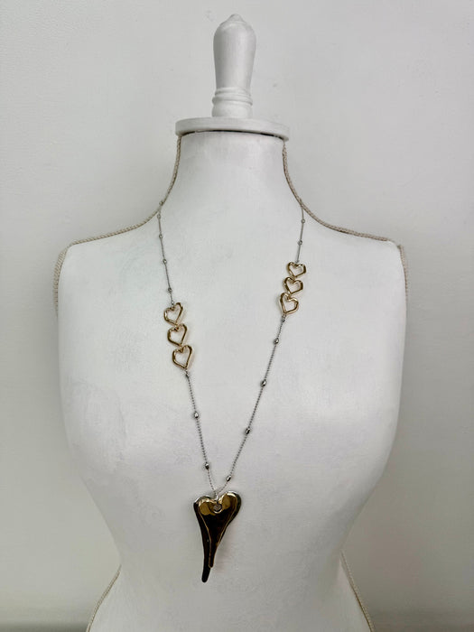 Necklace with heart-shaped pendants on a mannequin against a white background