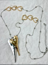Necklace with gold and silver heart-shaped pendants on a light gray background