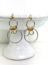 Gold and silver hoop earrings on a white stand