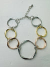 An elegant bracelet with a mix of silver, gold, and rose gold open circles linked together.