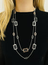 Long necklace with square pendants on a black sweater