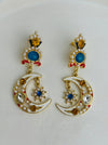 Pair of decorative earrings with moon and star design on a white background