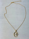 Gold necklace with a moon and star pendant on a light gray background