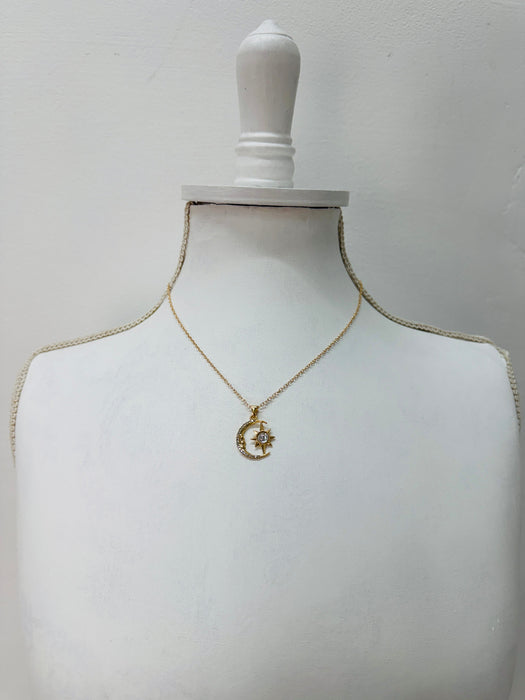 Gold necklace with a pendant on a mannequin bust against a plain background