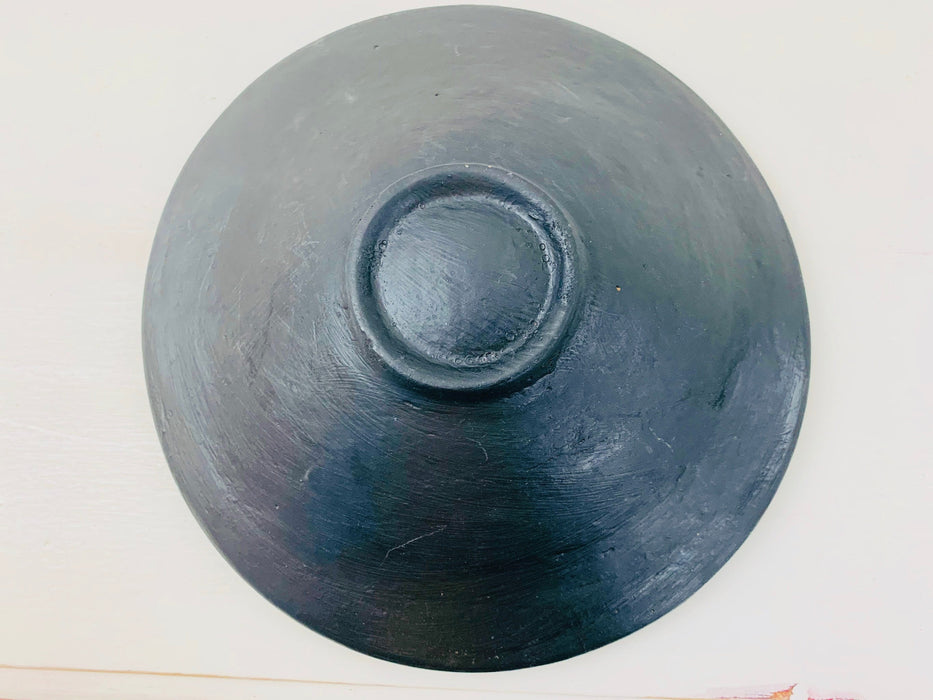 Bottom view of handmade mosaic bowl showing smooth terracotta base in dark finish.