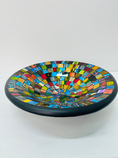 Handmade mosaic glass bowl in bright Sterope colours, showing curved terracotta base and reflective glass surface.