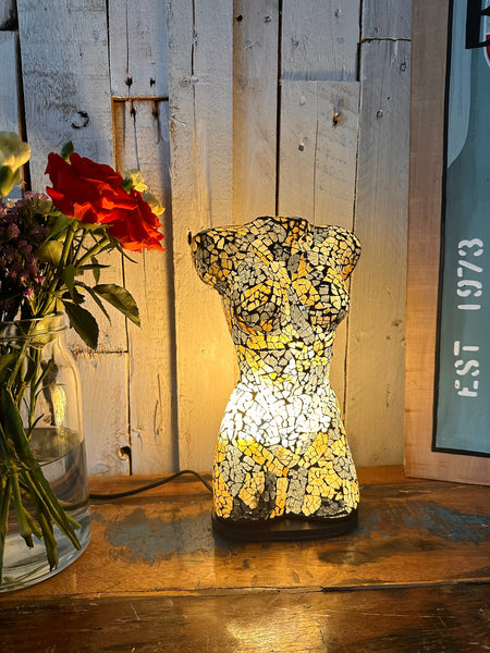 Handmade mosaic bust lamp glowing warmly in black and gold tones.