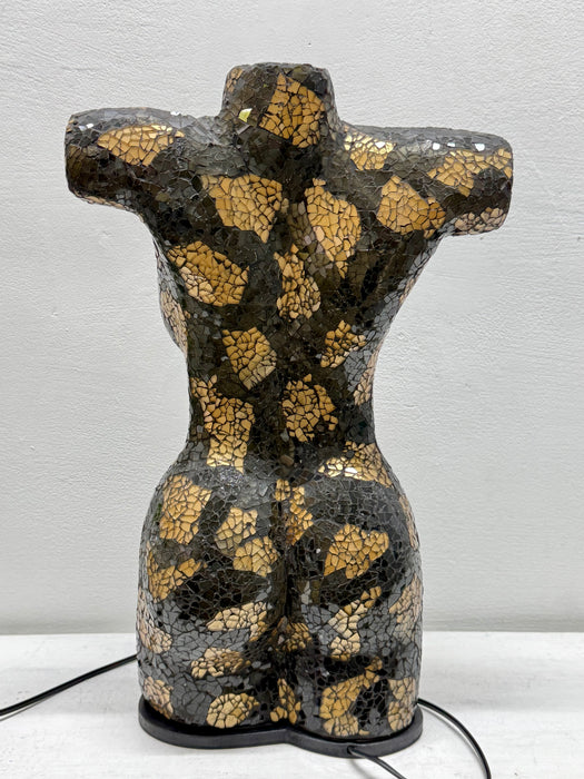 A decorative ceramic torso sculpture with a glossy black and gold mosaic crackle pattern, displayed against a light gray wall.