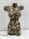 A decorative ceramic torso sculpture with a glossy black and gold mosaic crackle glaze, displayed on a white surface against a white wall.
